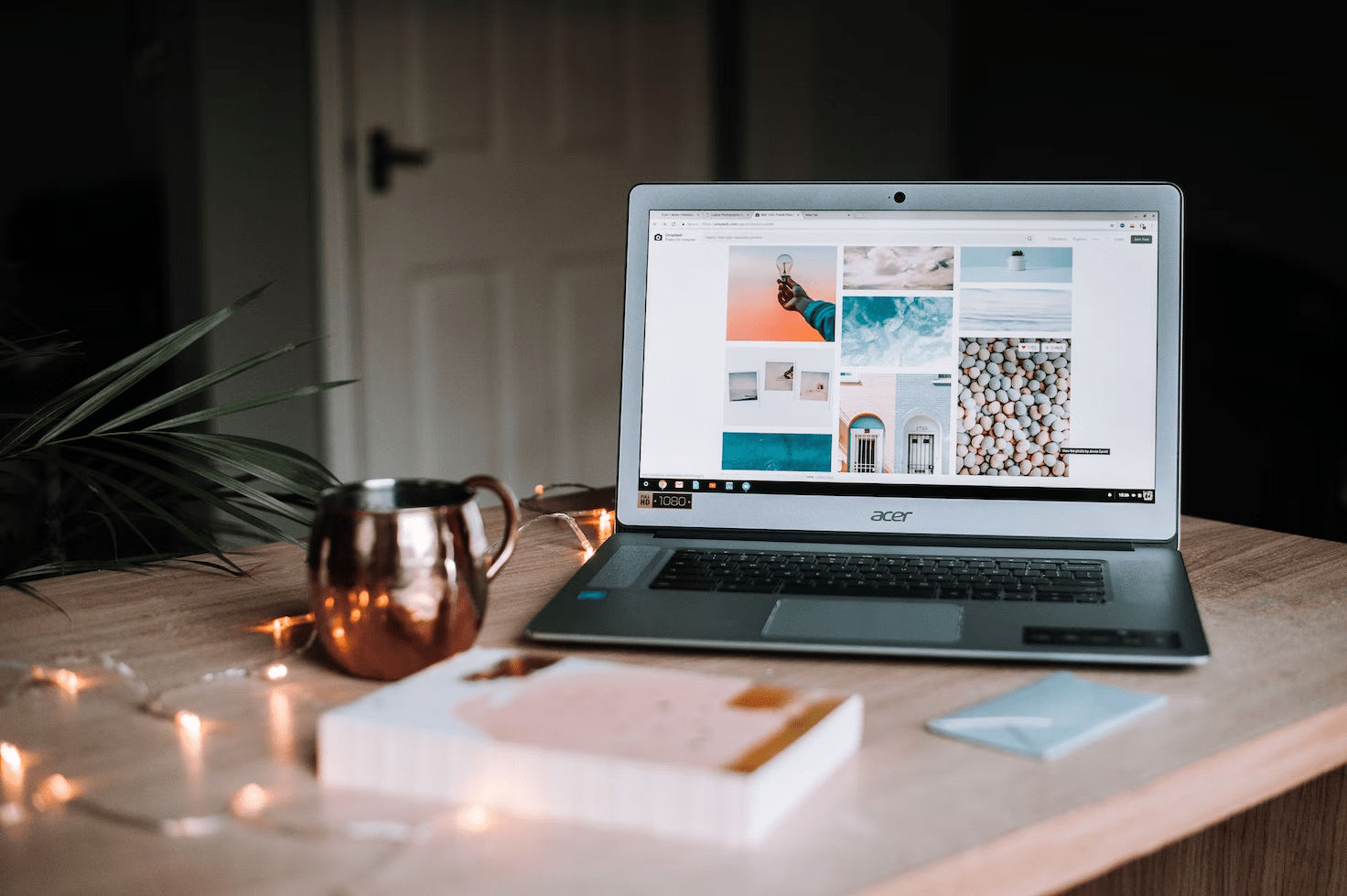 a laptop, a mug and a book on a desk