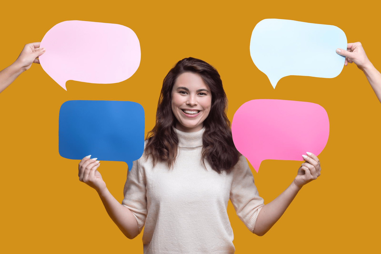 woman smiling and holding paper text balloons