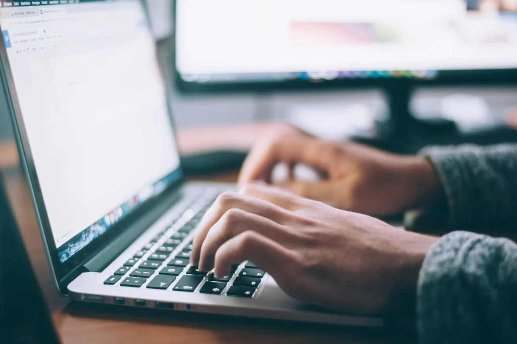 Close-up photo of hands typing on a laptop keyboard, used to illustrate how Hotjar can affect site speed and page performance.