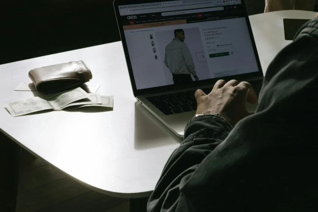 Person browsing products on an ecommerce website using a laptop at a desk.