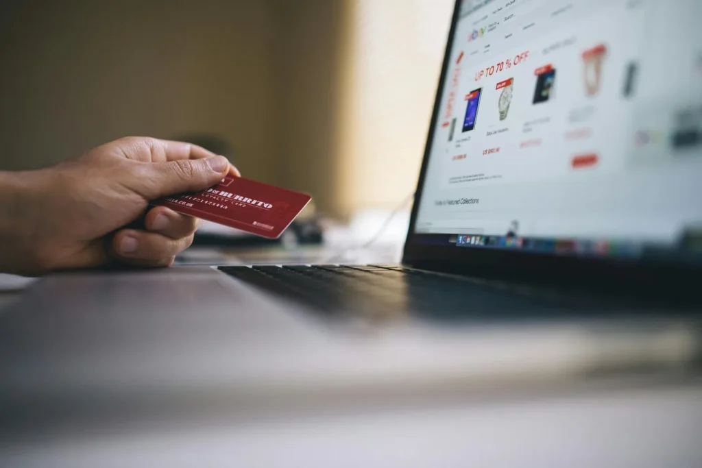 Customer using a credit card to complete an online ecommerce purchase on a laptop.