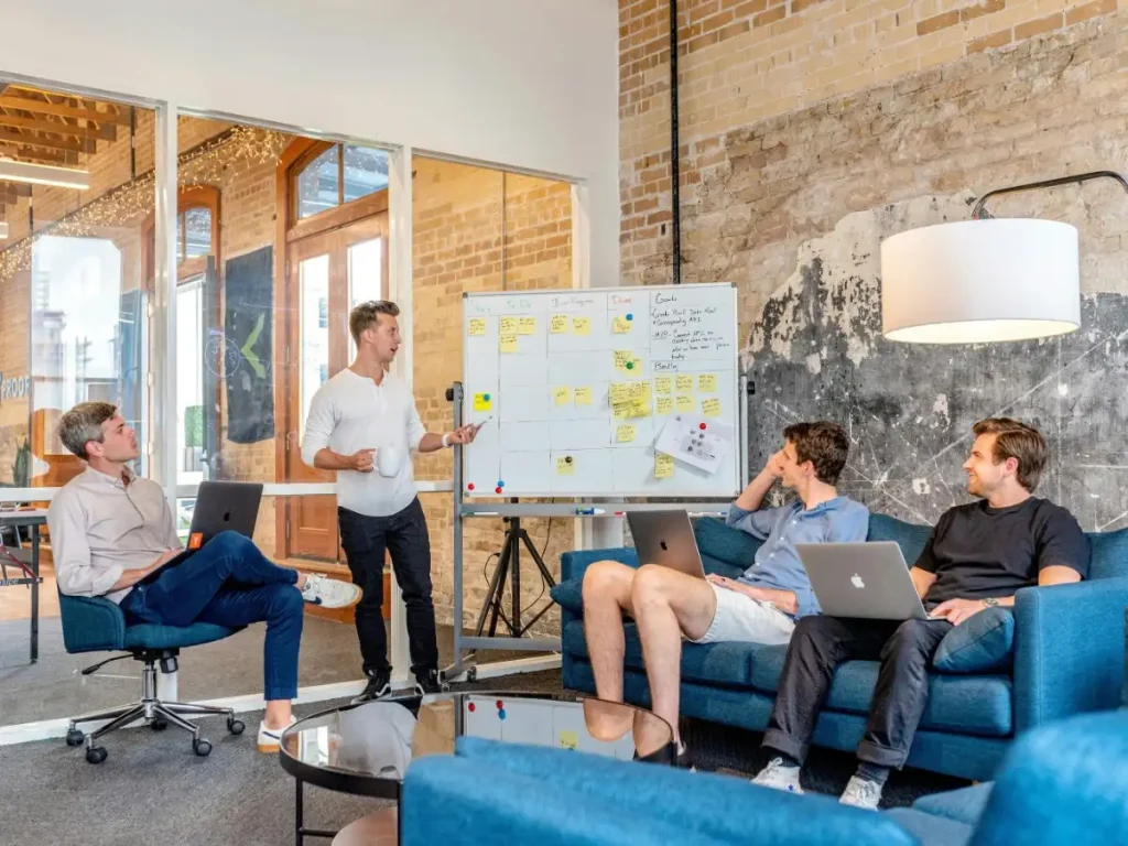 Team reviewing SaaS growth ideas on a whiteboard during a collaborative workshop.